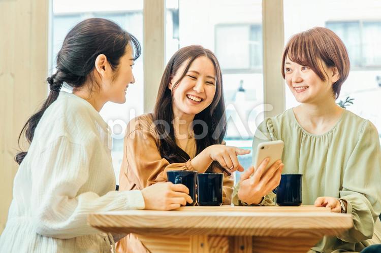 女子会でスマホを見る女性たち 女子会,スマートフォン,食事会の写真素材