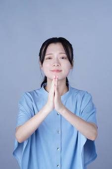 ごめんなさいポーズの青い服の女性 女性,ごめんなさい,合掌の写真素材