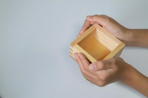 白い背景で枡を持つ手 枡,手元,日本酒の写真素材