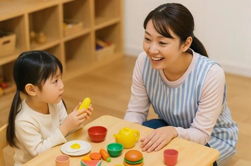 おままごと遊びをする園児と会話する保育士 おままごと遊びをする園児と会話する保育士の写真