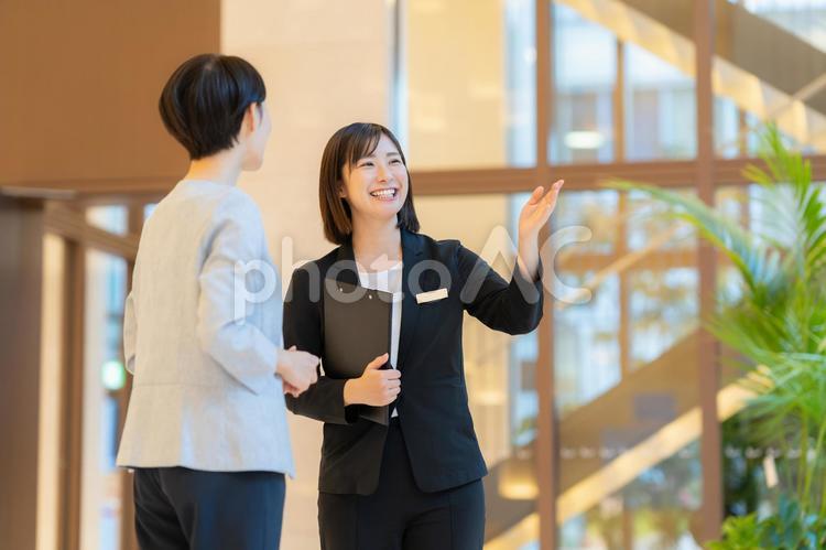 お客を案内するホテルマンの女性 フロント,ホテルマン,女性の写真素材