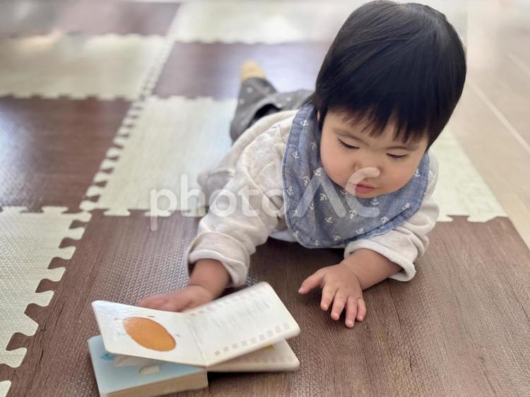 寝転んで絵本を読んでいる子ども 子ども,絵本,寝転ぶの写真素材