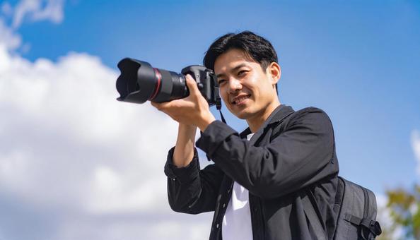 レンズを向ける日本人男性カメラマンの写真
