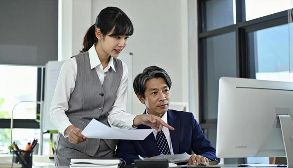 上司にデータを説明する女性社員 上司にデータを説明する女性社員の写真
