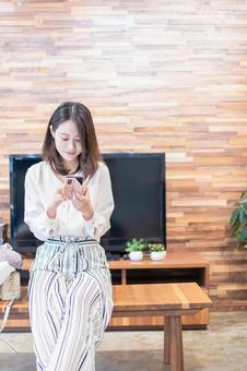 リビングでスマホを使う主婦 ネット,コミュニケーション,操作の写真素材