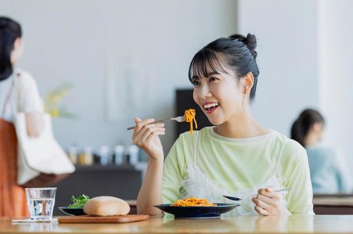 カフェでランチをする若い女性 カフェでランチをする若い女性の写真