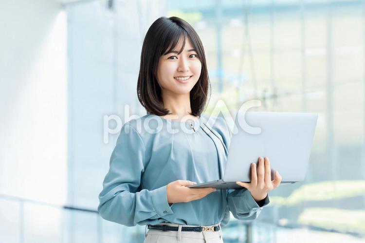 ノートパソコンを持つ笑顔の女性 女性,パソコン,笑顔の写真素材