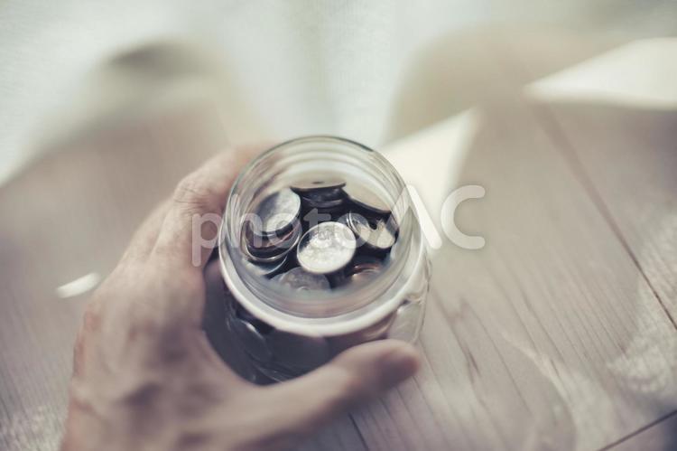 瓶に入った日本硬貨を持つ人の手 お金,小銭,コインの写真素材