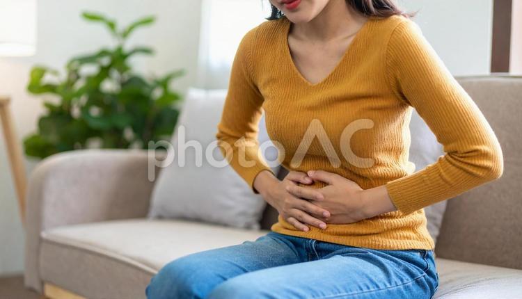 ソファで腹痛に苦しむ女性 腹痛,痛い,便秘の写真素材