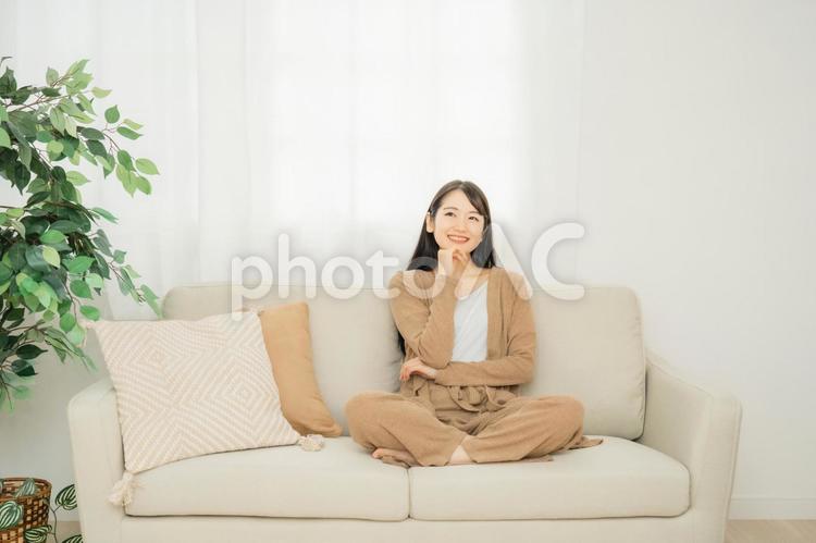 家のソファに座る女性 リビング,女性,ソファの写真素材