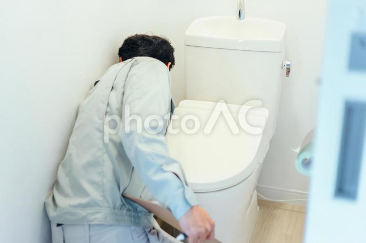 トイレのチェックをする作業着の男性 トイレ,トイレ修理,修理の写真素材