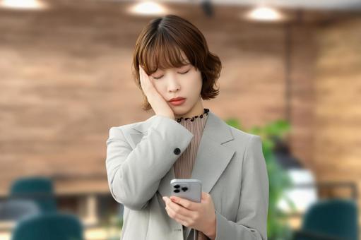 スマホを見て悩む女性・ビジネスウーマン 女性,スマホ,悩むの写真素材