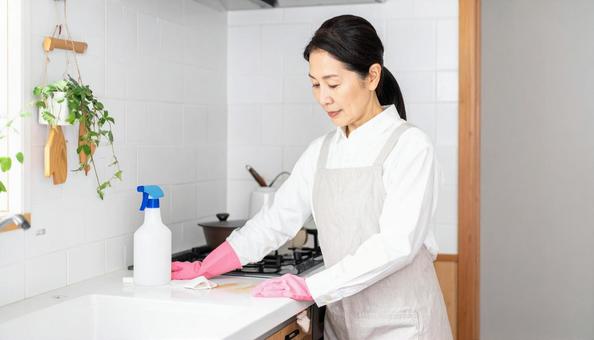 キッチンの汚れに困る日本人の主婦 キッチンの汚れに困る日本人の主婦の写真