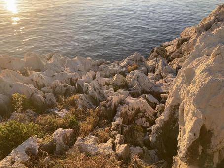 沈む夕日の岩場 沈む夕日の岩場の写真