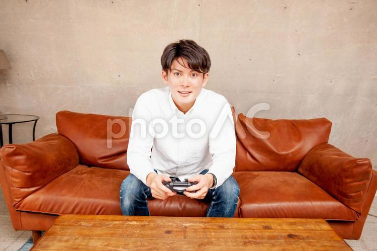 部屋でゲームをする男性 ゲーム,オンラインゲーム,テレビゲームの写真素材