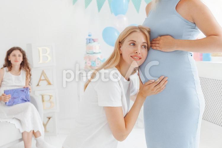 妊婦のお腹に顔をつけている女性と座っている女性 女性,人物,座るの写真素材