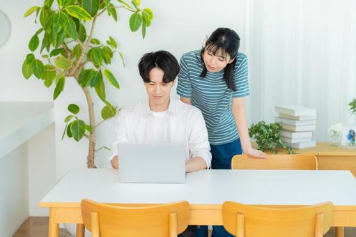 パソコンを見るカップル ノートパソコン,笑顔,カップルの写真素材