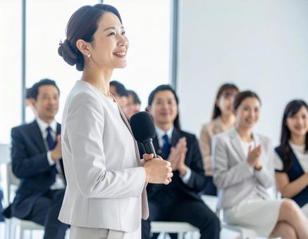 学会で登壇する女性と聴衆の写真