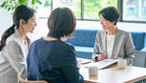 女性営業マンの説明を聞く親子 女性営業マンの説明を聞く親子の写真