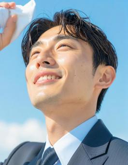 汗をふく男性ビジネスマン 汗をふく男性ビジネスマンの写真