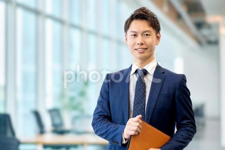 バインダーを持つ笑顔の男性ビジネスマン 男性,ビジネス,ビジネスマンの写真素材
