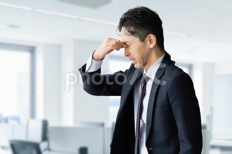 目の疲れに悩まされる男性ビジネスマン 男性,ビジネス,ビジネスマンの写真素材