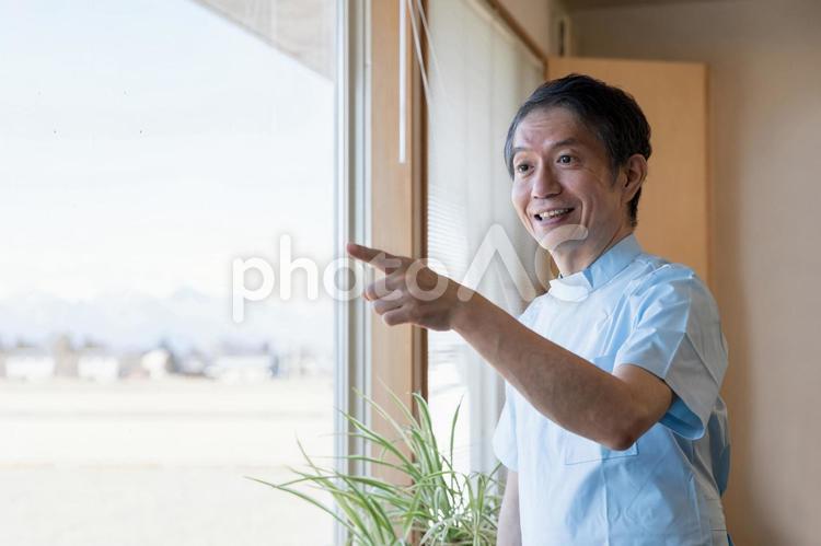 窓の外を見る医師（笑顔） 医師,医者,笑顔の写真素材