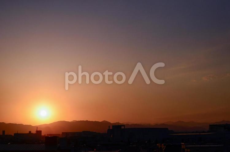 山に落ちていく太陽、夕焼けの空 太陽,景色,夕焼けの写真素材