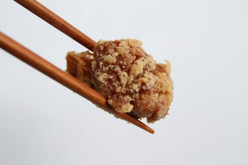箸で持つ唐揚げ 箸で持つ唐揚げの写真