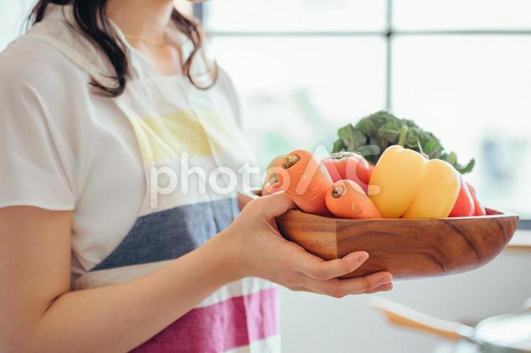 キッチンで野菜を持つ女性（顔なし） 野菜,主婦,料理の写真素材