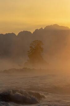 神々しい雨晴海岸の毛嵐と日の出直前_縦 毛嵐,日の出,朝焼けの写真素材