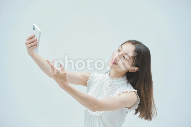 スマートフォンを持ちながら舞う若い女性  女性,スマホ,スマートフォンの写真素材