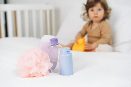 ベッドの上に置かれたバスグッズとお座りする子供 ベッドの上に置かれたバスグッズとお座りする子供 ベビー用品,スキンケア,バスグッズの写真素材