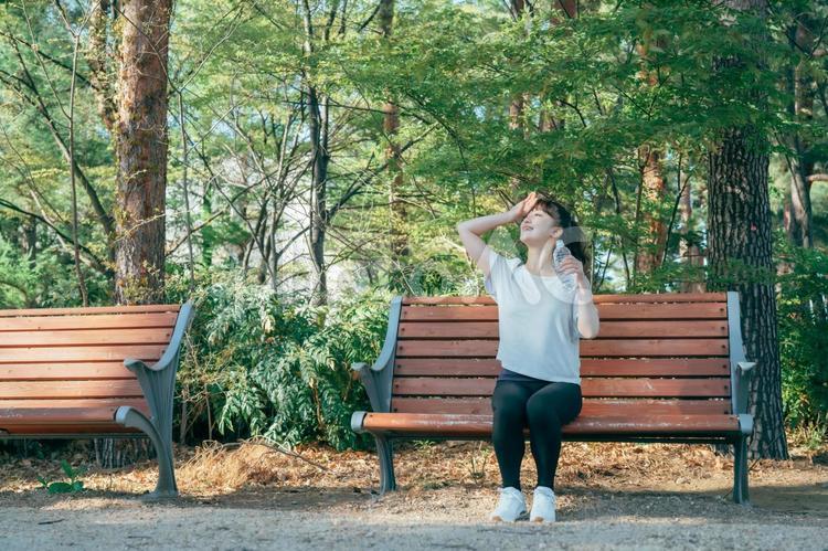 トレーニング中に休憩する女性（水を飲む・笑顔） 水分補給,汗,水の写真素材