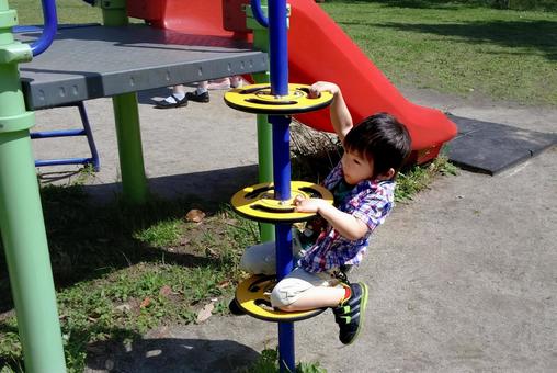 <素材>公園の遊具で遊ぶ男の子 <素材>公園の遊具で遊ぶ男の子の写真