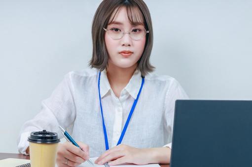 デスクワークをする女性のクローズアップ デスクワークをする女性のクローズアップ 女性,若い,眼鏡の写真素材