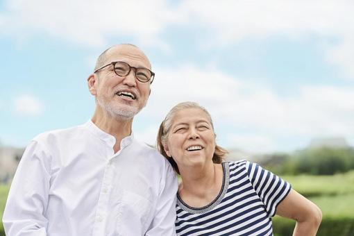 Elderly couple standing with a smile against the blue sky, senior citizens, couple, blue sky, JPG