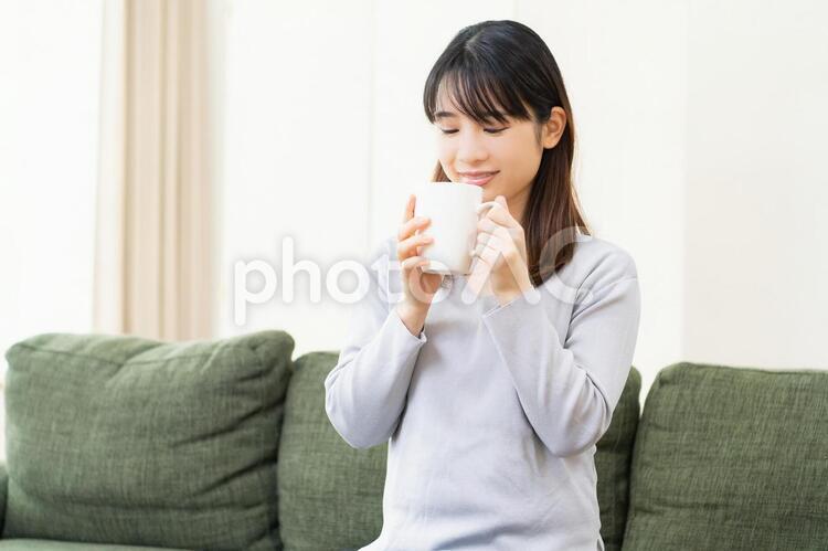 リビングのソファでコーヒーを飲む女性 女性,コーヒー,飲むの写真素材