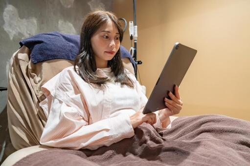 タブレットを操作する女性 まつ毛,アイラッシュ,タブレットの写真素材