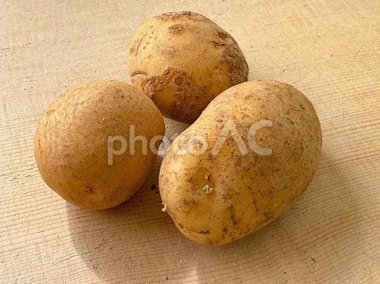 まな板に置かれたじゃがいも3個 じゃがいも,芋,根菜の写真素材