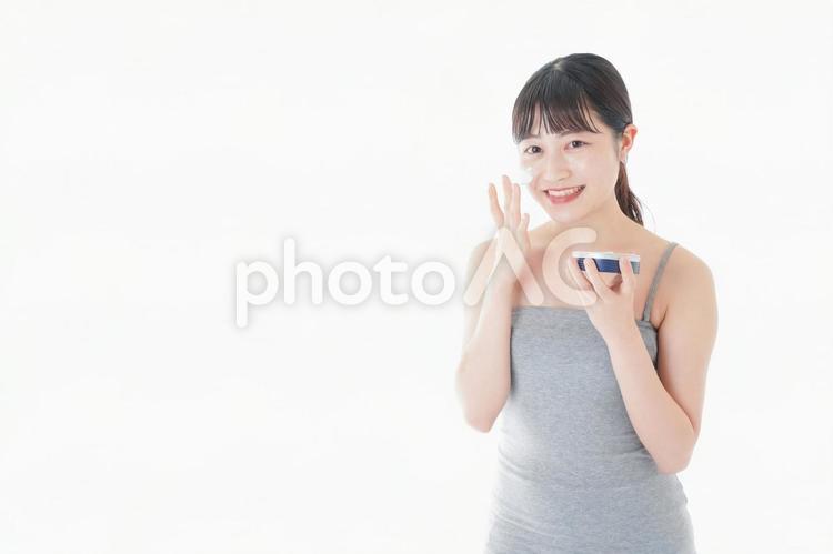 顔にクリームを塗る若い女性 ノーメイク,日本人,メイク落としの写真素材