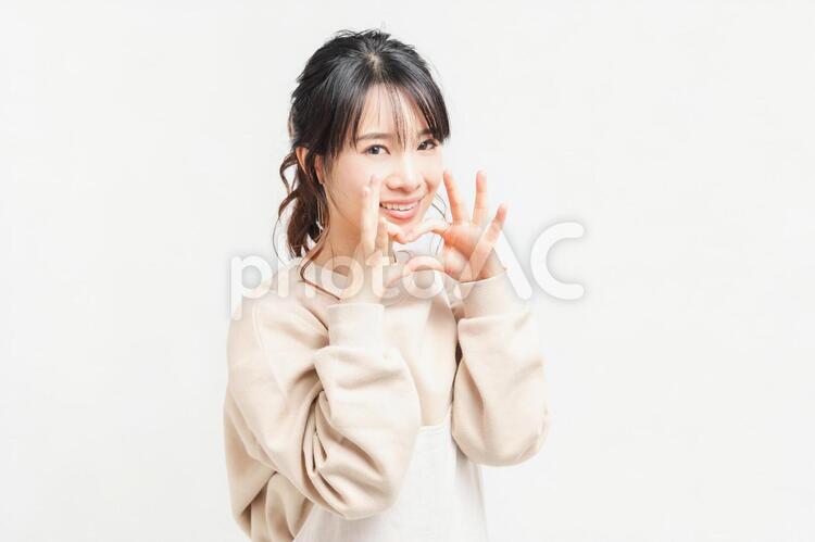 手でハートの形を作る若い女性 女性,ハート,愛情の写真素材