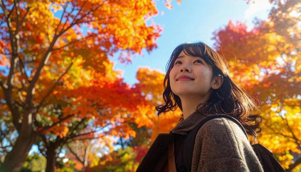 紅葉鑑賞を楽しむ笑顔の若い女性 紅葉鑑賞を楽しむ笑顔の若い女性の写真
