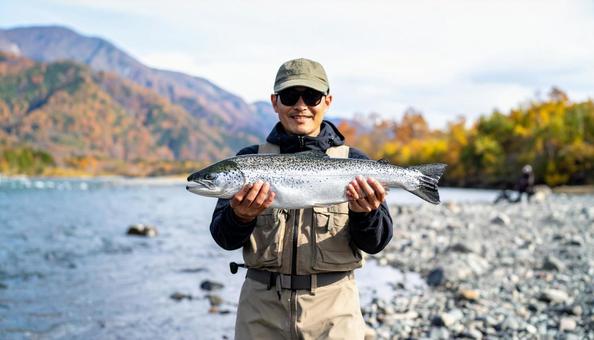 釣果を見せるサングラスの日本人男性 釣果を見せるサングラスの日本人男性の写真