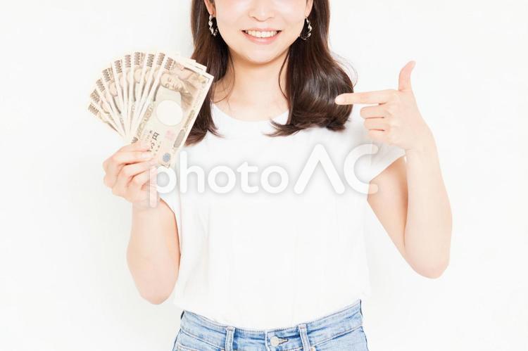 お金を持って喜んでいるTシャツを着た若い女性 お金,女性,金の写真素材