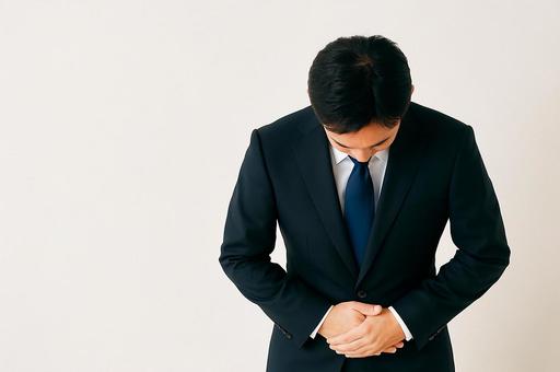 深く頭を下げて謝罪するビジネスマンの姿の写真