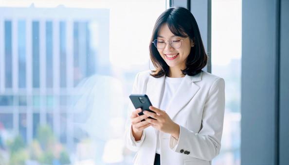 スマホを確認するビジネス女性 スマホを確認するビジネス女性の写真