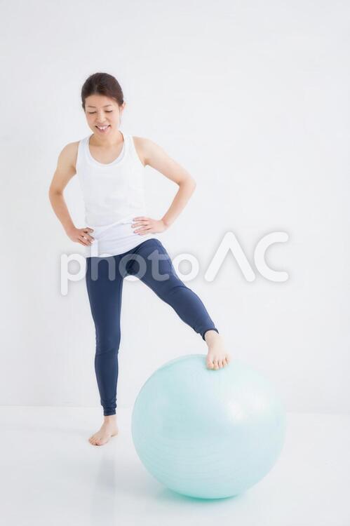 スポーツウェアをきた女性 バランスボール,ストレッチ,美脚の写真素材