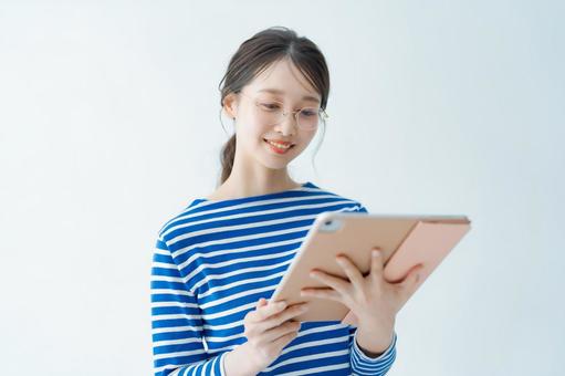 Young woman looking at the screen of a tablet PC, fem, pc, japonais, JPG