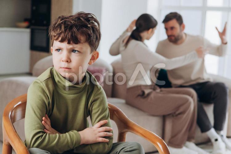 喧嘩する両親と腕を組んであぐらの男の子 親子,男の子,両親の写真素材